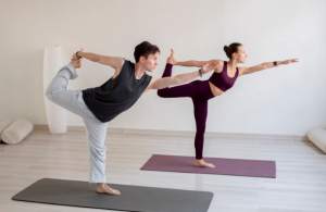 joven espiritual y mujer practicando yoga en el interior